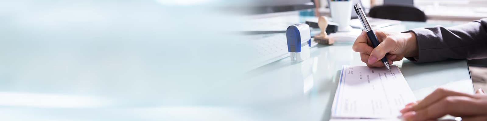 A hand filling out a paper check
